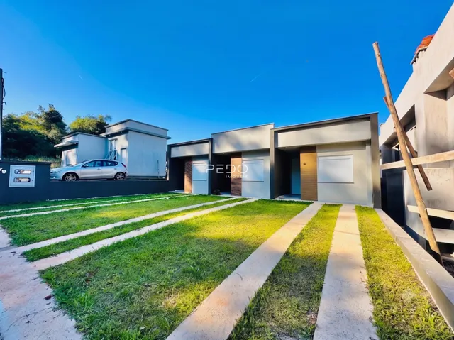 Fachada moderna de uma casa em Lajeado, Brasil, com jardim e calçadas de concreto.