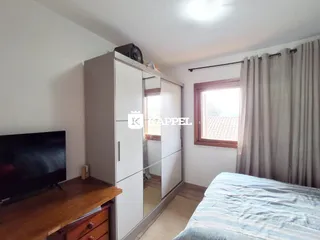 Foto de um quarto com cama e armário branco em um imóvel.