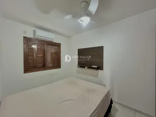 Quarto com cama e armários de madeira em um imóvel no Brasil.