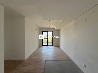 Hall de entrada com piso de madeira e paredes brancas.