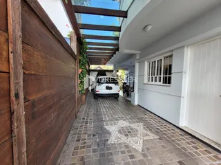 Fachada de uma residência com pátio pavimentado.