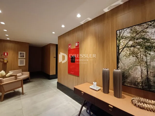 Sala de estar com revestimento de madeira e piso claro.