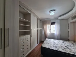 Quarto com armários embutidos e cama em um ambiente claro.