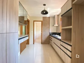 Cozinha moderna com armários brancos e piso claro.