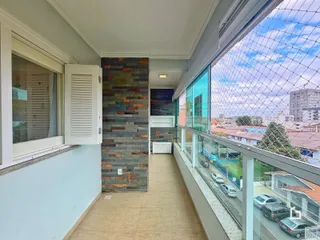 Vista interna de um corredor com parede de pedra e vista para a cidade.