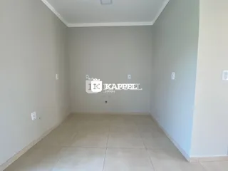 Vista interna de um cômodo com paredes brancas e piso de cerâmica.