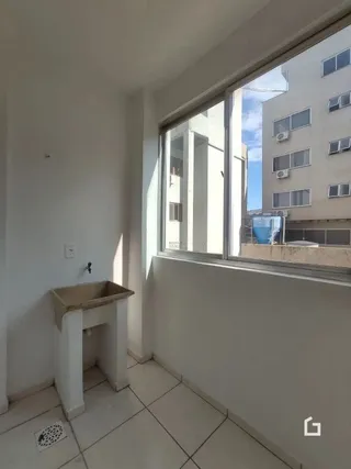 Interior com parede branca e piso de cerâmica ao lado de uma janela.