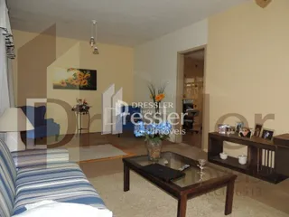 Sala de estar com sofá e mesa de centro em ambiente interno.
