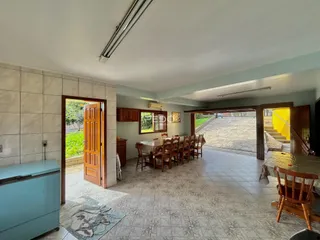 Interior de uma sala de jantar com piso de cerâmica e portas de madeira.