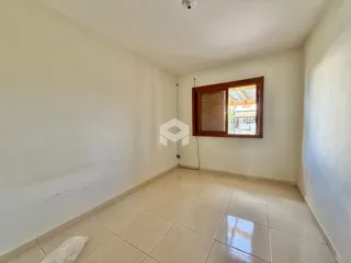 Vista de um corredor interno com paredes brancas e piso de cerâmica.