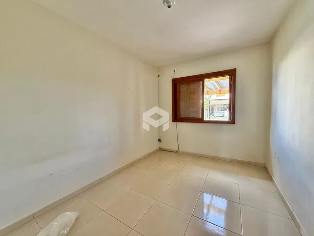 Vista de um corredor interno com paredes brancas e piso de cerâmica.