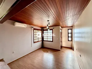 Sala de estar com piso de madeira e teto de madeira.