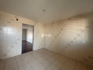 Corredor interno com piso de cerâmica e paredes brancas.