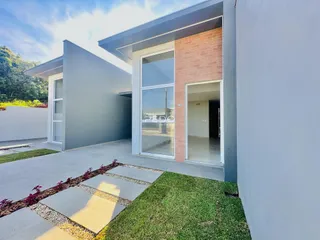 Fachada moderna de uma residência com piso de concreto e jardim em Lajeado, Brasil.