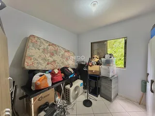 Quarto com cabeceira decorativa e janela no interior de uma residência.