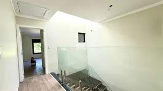 Vista de um corredor interno com escada de vidro.