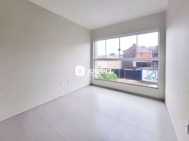 Foto de um ambiente interno com paredes brancas e piso claro.