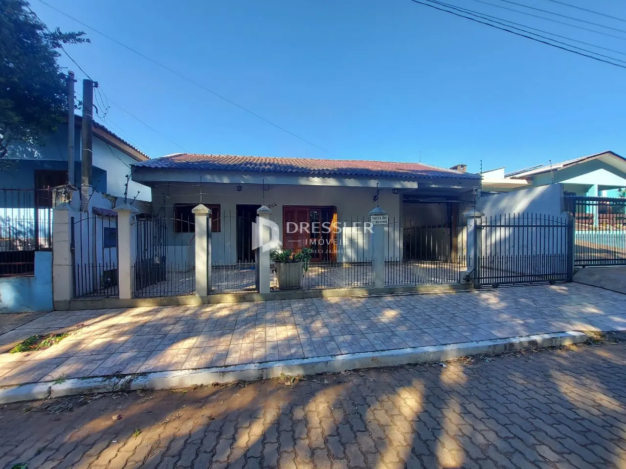Fachada de uma residência em Lajeado, Brasil, com cerca e portão de ferro.