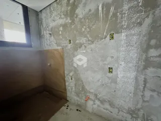 Parede interna com acabamento de concreto aparente em uma residência.