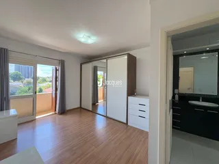 Sala de estar com piso de madeira e porta de vidro que dá para o exterior.