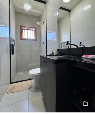 Um banheiro com revestimento cerâmico e louças sanitárias.