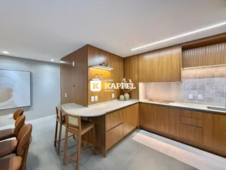 Uma cozinha moderna com armários de madeira e iluminação em Lajeado.