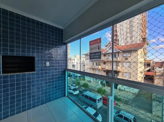 Interior com paredes azuis e vista para construções externas.