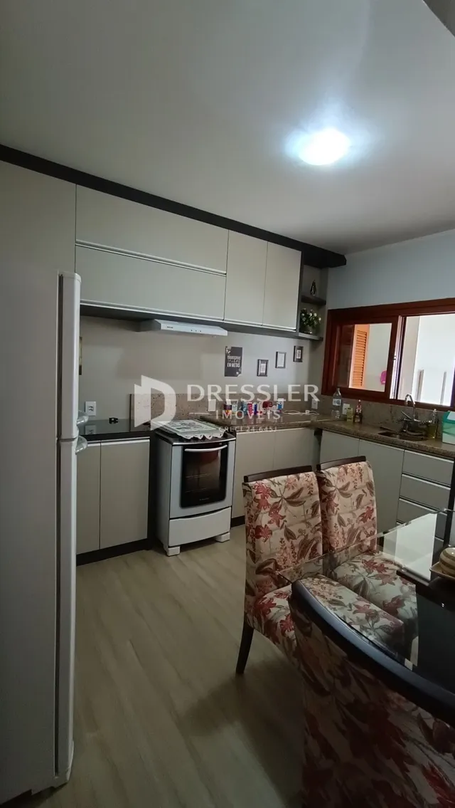 Interior de uma sala de estar com cozinha em um imóvel no Brasil.
