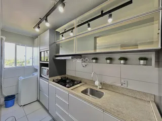 Cozinha com armários brancos e bancada clara.