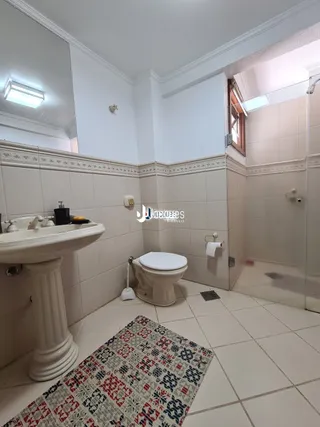 Foto de um banheiro interno com piso de cerâmica branca.