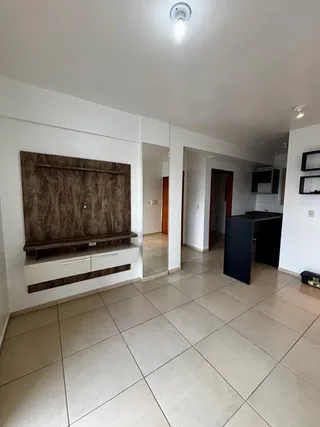 Ambiente interno com piso de cerâmica e painel de madeira em uma área comum.