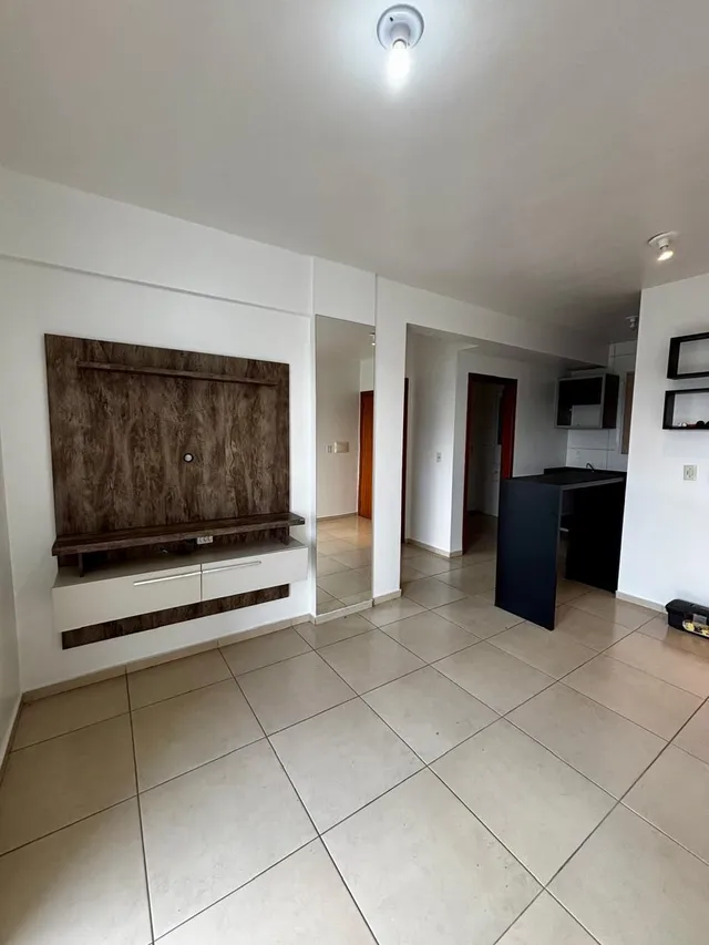 Ambiente interno com piso de cerâmica e painel de madeira em uma área comum.