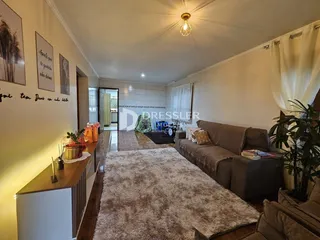 Sala de estar com sofá e piso de madeira em uma residência.