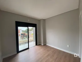 Interior de uma sala com porta de vidro abrindo para o exterior.