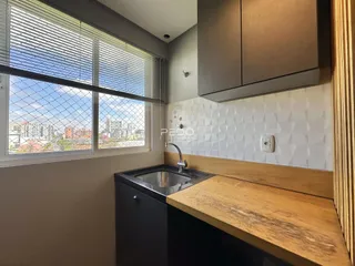 Vista de uma bancada de cozinha com janela para a cidade.