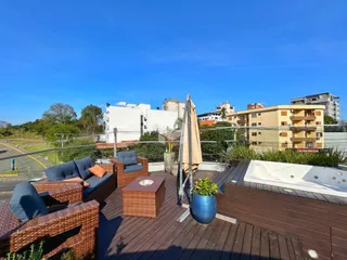 Vista de uma área de lazer externa com deck e jacuzzi em Lajeado.