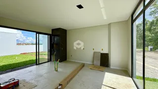 Ambiente interno com piso de concreto e porta de vidro que dá para o exterior.