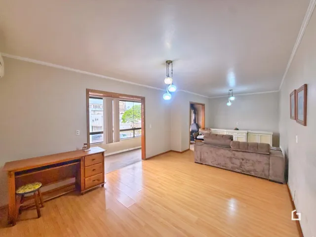 Sala de estar com piso de madeira clara e paredes brancas.
