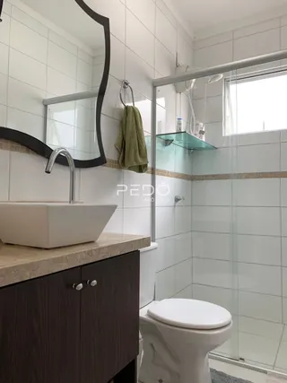 Foto de um banheiro moderno com box de vidro e azulejos brancos.