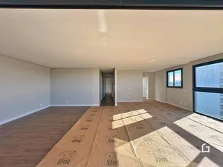 Interior de uma sala com piso de madeira clara.