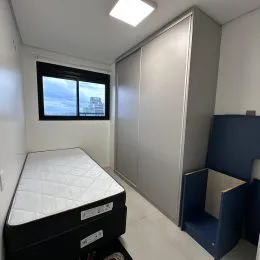 Foto interna de um quarto com cama e janela.
