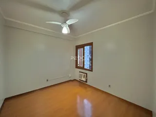 Sala de estar com piso de madeira e teto branco.