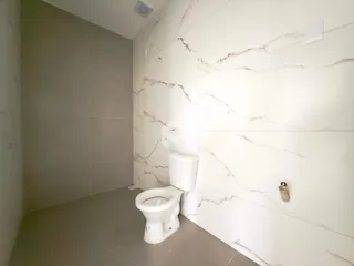 Foto de um banheiro com revestimento de mármore nas paredes.