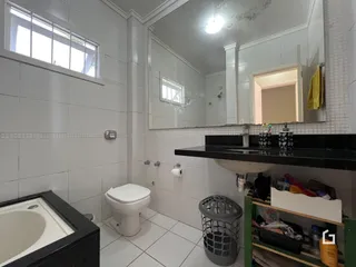 Foto de um banheiro interno com piso cerâmico e janela.