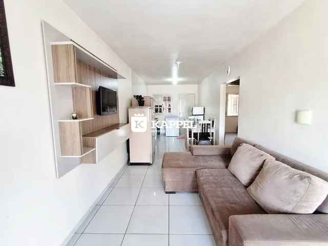 Foto de uma sala de estar com sofá e estante na parede.
