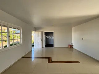 Ambiente interno de uma sala com piso de cerâmica e janela.