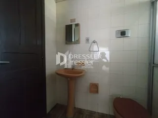 Foto de um banheiro com paredes brancas e piso de cerâmica.