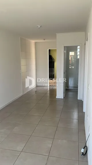 Corredor interno de uma residência com piso de cerâmica.