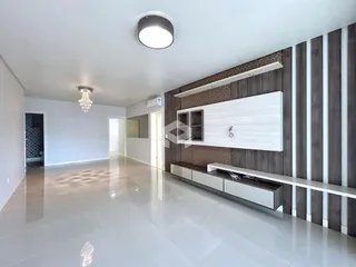 Ambiente interno de uma sala ampla com piso claro e paredes brancas.