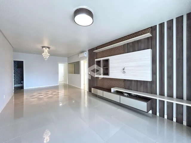 Ambiente interno de uma sala ampla com piso claro e paredes brancas.